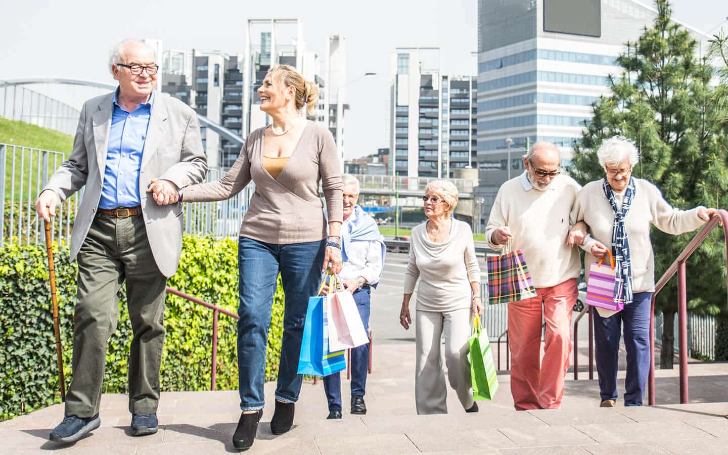 Groups of seniors walking with shopping bags in downtown city