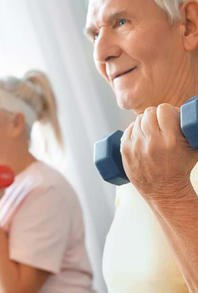 Senior man hold hand weights next to a woman holding hand weights